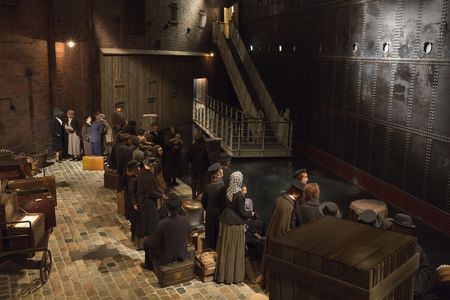 Abschied an der Kaje - Szene aus dem Deutschen Auswandererhaus. Menschliche Puppen stehen an einer Kaje. Davor eine dunkle Schiffswand mit einer Gangway