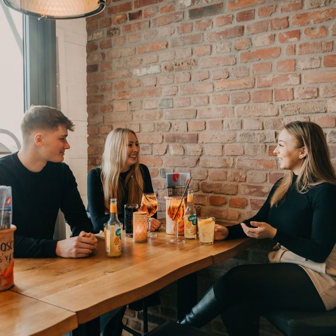 Drei junge Menschen sitzen in einem Restaurant zusammen