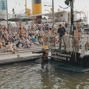 Viele Menschen verfolgen die Vorführung an Bord von Taucher Bremenports