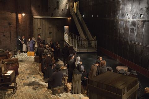 Abschied an der Kaje - Szene aus dem Deutschen Auswandererhaus. Menschliche Puppen stehen an einer Kaje. Davor eine dunkle Schiffswand mit einer Gangway