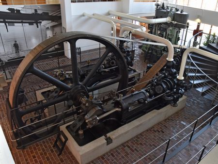 Historische Kältemaschine mit Schwungrad und Rohrleitungen im Industrieraum des Museums.