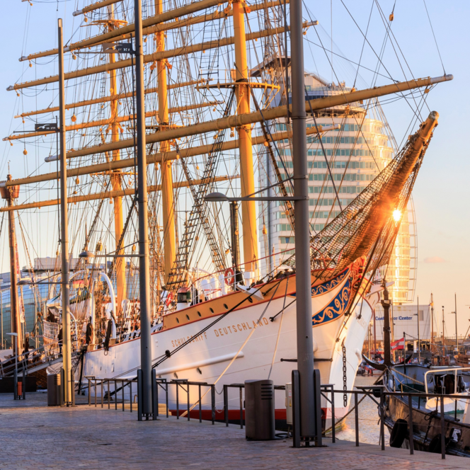 Das historische Segelschiff Schulschiff Deutschland liegt im Sonnenlicht am Kai des Neuen Hafens.