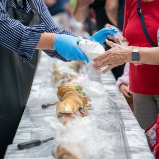 Ein rund 30 Meter langes Matjesbrötchen wird angeschnitten