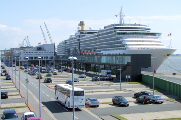 Kreuzfahrtschiff am Terminal Columbuskaje mit Parkplätzen und Gangway.