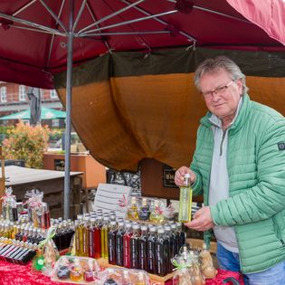 Ein Verkäufer präsentiert seine Ware auf dem Bauernmarkt im Schaufenster Fischereihafen