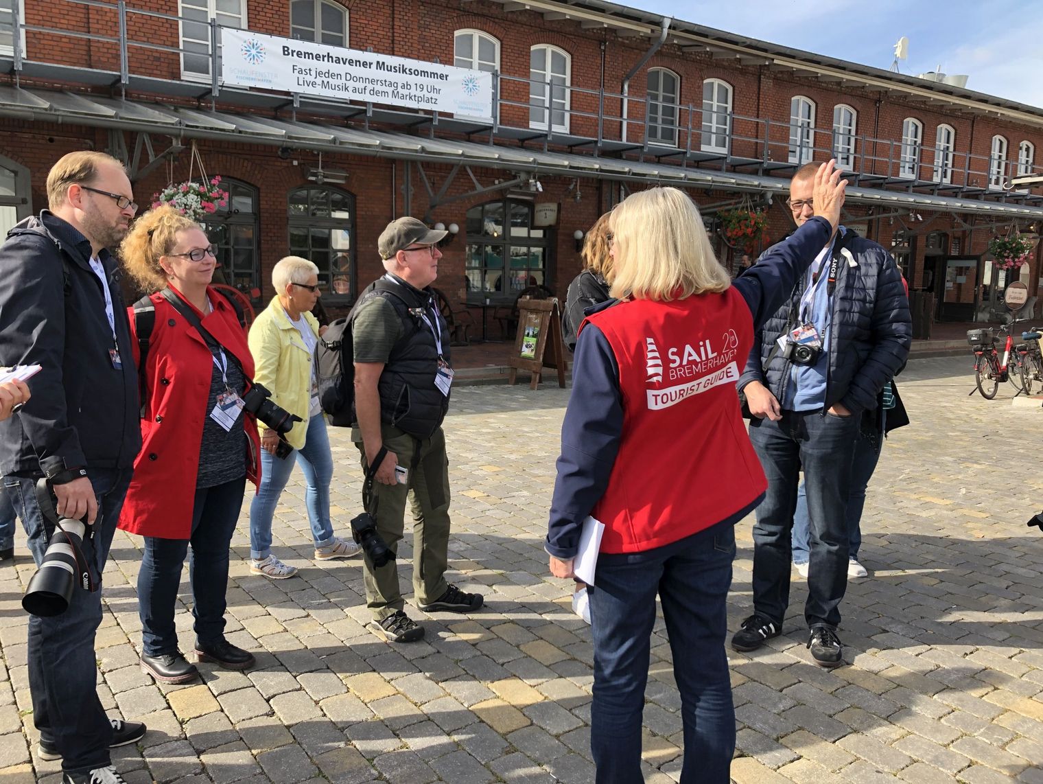 Eine Gästeführerin begleitet eine Gruppe durch das Schaufenter Fischereihafen