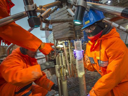 Drei Personen vom AWI arbeiten an einer Maschine.