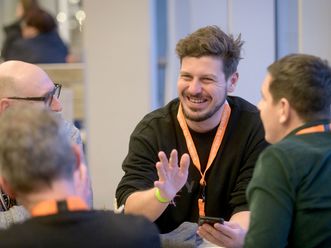 Vier Menschen sitzend diskutierend am Tisch