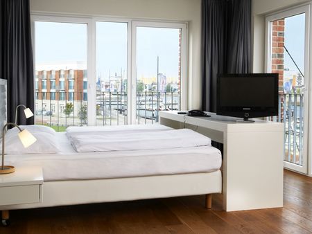 Blick vom Schlafzimmer aus dem im Jaich-Hotelzimmer hinaus auf die Marina mit Sport- und Segelbooten