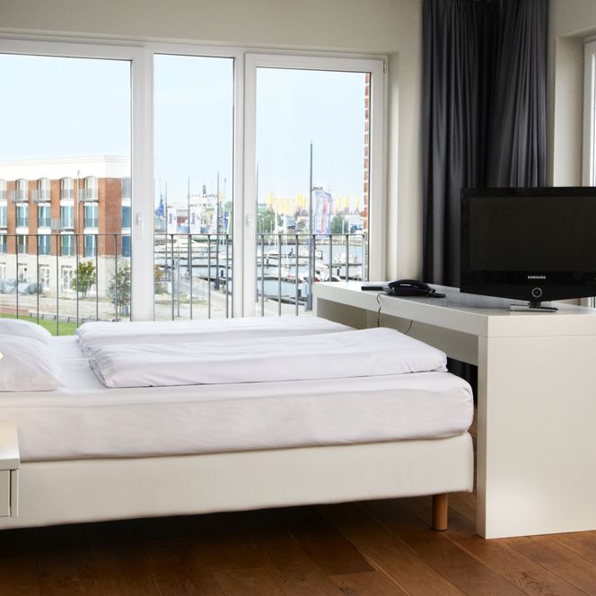 Blick vom Schlafzimmer aus dem im Jaich-Hotelzimmer hinaus auf die Marina mit Sport- und Segelbooten