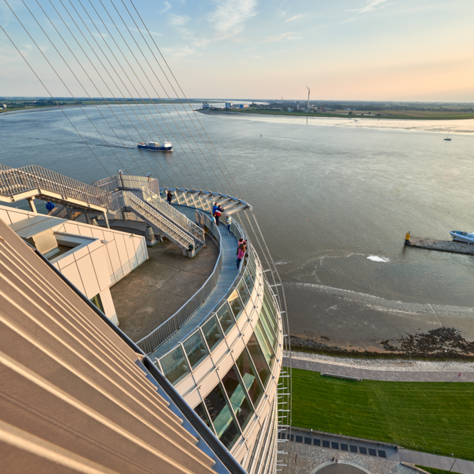 Blick von der Aussichtsplattform SAiL City auf die Weser mit vorbeifahrenden Schiffen bei Sonnenlicht.