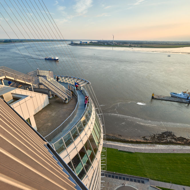Blick von der Aussichtsplattform SAiL City auf die Weser mit vorbeifahrenden Schiffen bei Sonnenlicht.