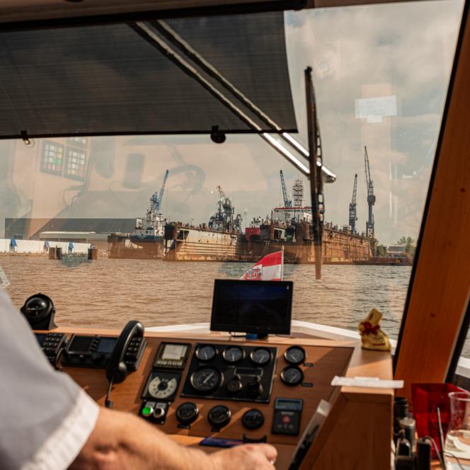 Blick aus dem Steuerhaus eines Ausflugsschiffs auf den Überseehafen Bremerhavens mit Kränen
