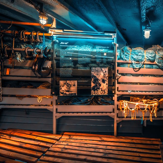Ausstellungsraum im Museumsschiff Gera mit Netzen, Haken und maritimen Arbeitsgeräten an Bord
