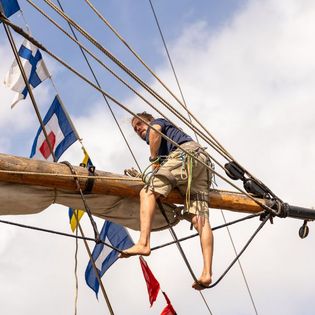 Mann sitzt hoch in den Masten