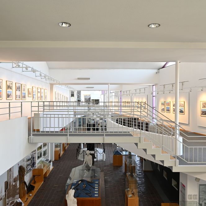 Innenansicht des Historischen Museums Bremerhaven mit Treppenanlage und beleuchteter Ausstellung.