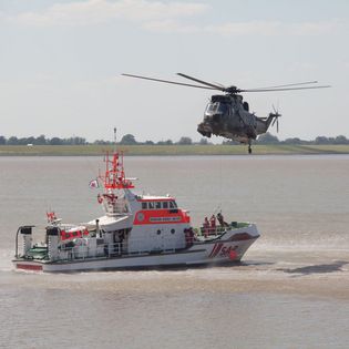 DGzRS-Boot auf der Weser mit darüber fliegendem Hubschrauber