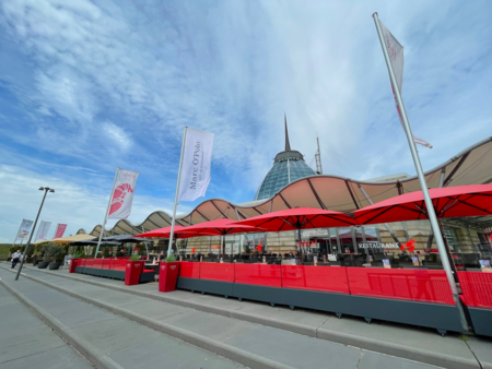 Rote Sonnenschirme auf der Außenterrasse des Restaurants Gosch Sylt am Hafen in Bremerhaven.