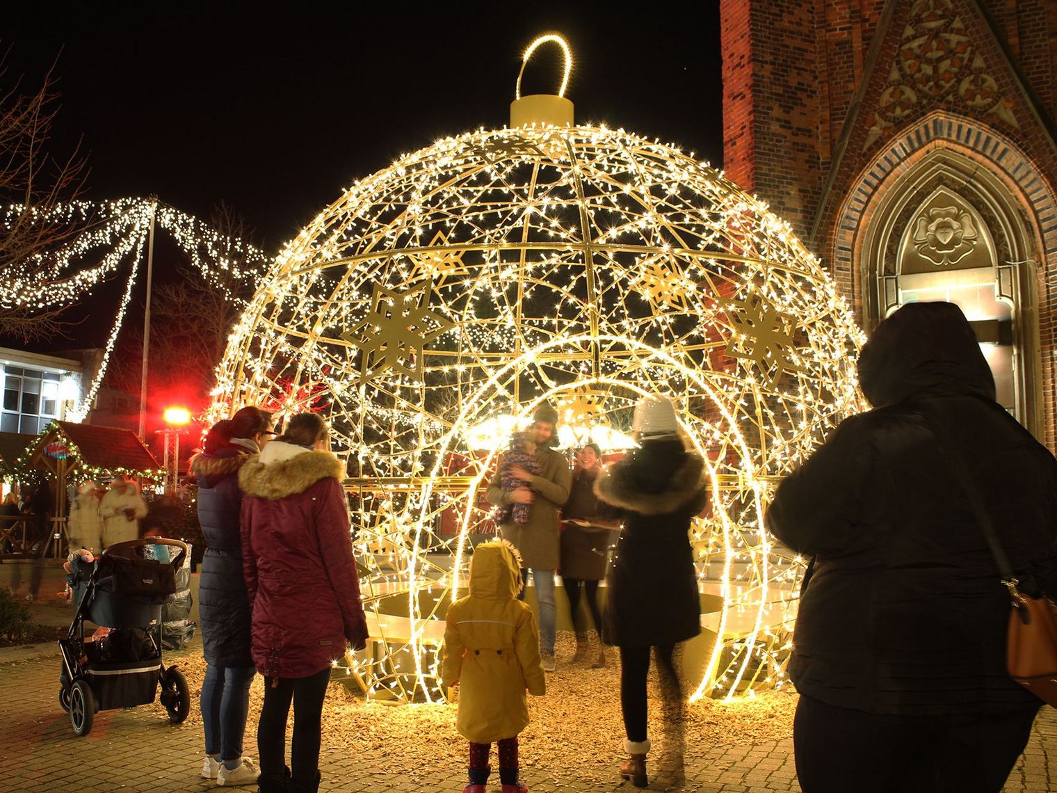 Große, beleuchtete begehbare Weihnachtskugel auf dem Weihnachtsmarkt