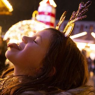 Mädchen fängt mit Zunge Schneeflocken