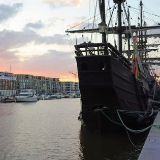 Sonnenuntergang über dem Neuen Hafen mit Blick auf das Heck der Nao Victoria