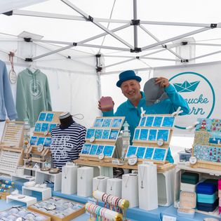 Ein Verkäufer präsentiert seine Ware auf dem Bauernmarkt im Schaufenster Fischereihafen