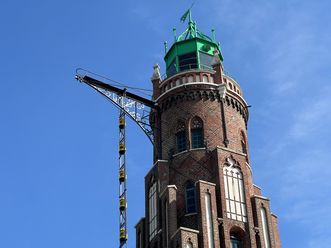 Blick auf die Backsteinspitze mit grünem Dach vom Simon-Loschen-Leuchtturm