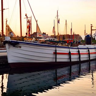 Das Helgoländer Börteboot Nr. 3 liegt im Neuen Hafen in Bremerhaven bei Sonnenuntergang
