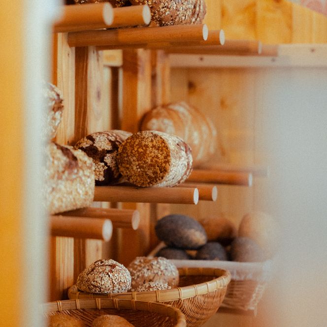 Selbstgebackenes Brot in einem Holzregal an der Wand