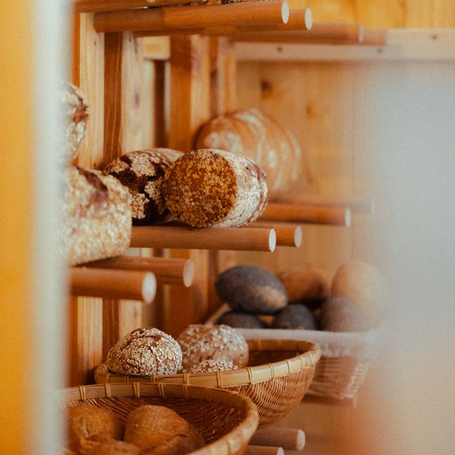 Selbstgebackenes Brot in einem Holzregal an der Wand