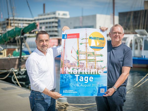 Zwei Männer halten ein Plakat hoch