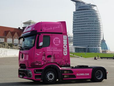 Foto zum Donsload Ein pinkfarbener Lkw parkt vor Bremerhavens Kulisse