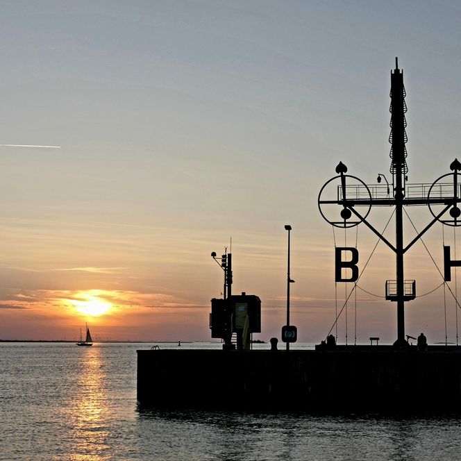 Sonnenuntergang über der Weser in Bremerhaven und über dem Semaphor auf der Kaimauer