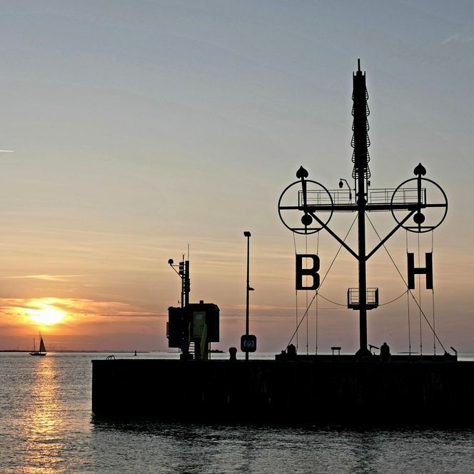 Sonnenuntergang über der Weser in Bremerhaven und über dem Semaphor auf der Kaimauer