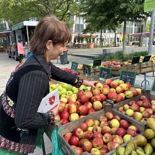 Eine Frau kauft Äpfel auf dem Wochenmarkt