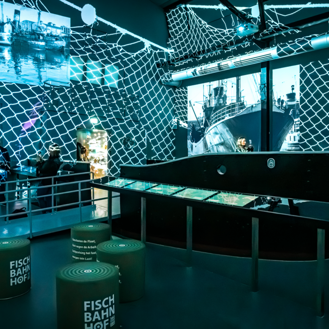 Innenraum des Erlebnismuseums Fischbahnhof 360° mit Lichtinstallation und maritimen Ausstellungsobjekten