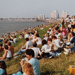 Sail 1986 - Menschen sitzen am Deich