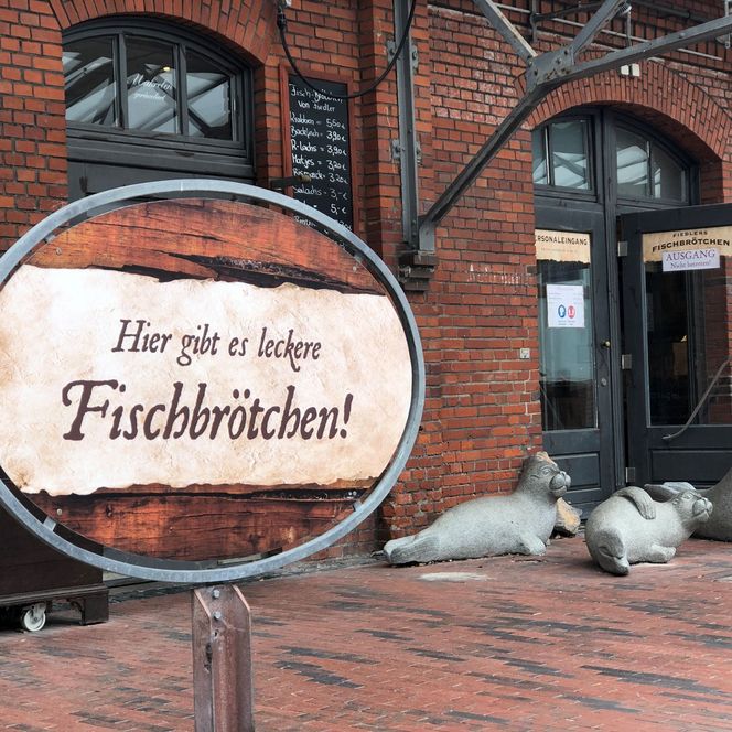 Schild mit Aufschrift Hier gibt es leckere Fischbrötchen