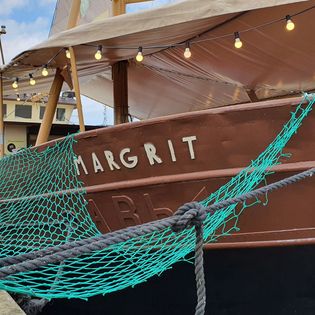 Blick auf den Bug der Margrit mit zur Kaje abgesichertem Netz