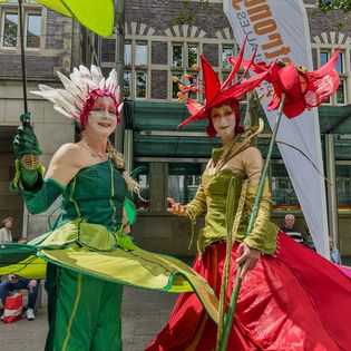 Frauen als Blumen verkleidet als Walk-Act