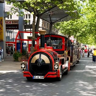 Eine Bimmelbahn fährt durch die Fußgängerzone